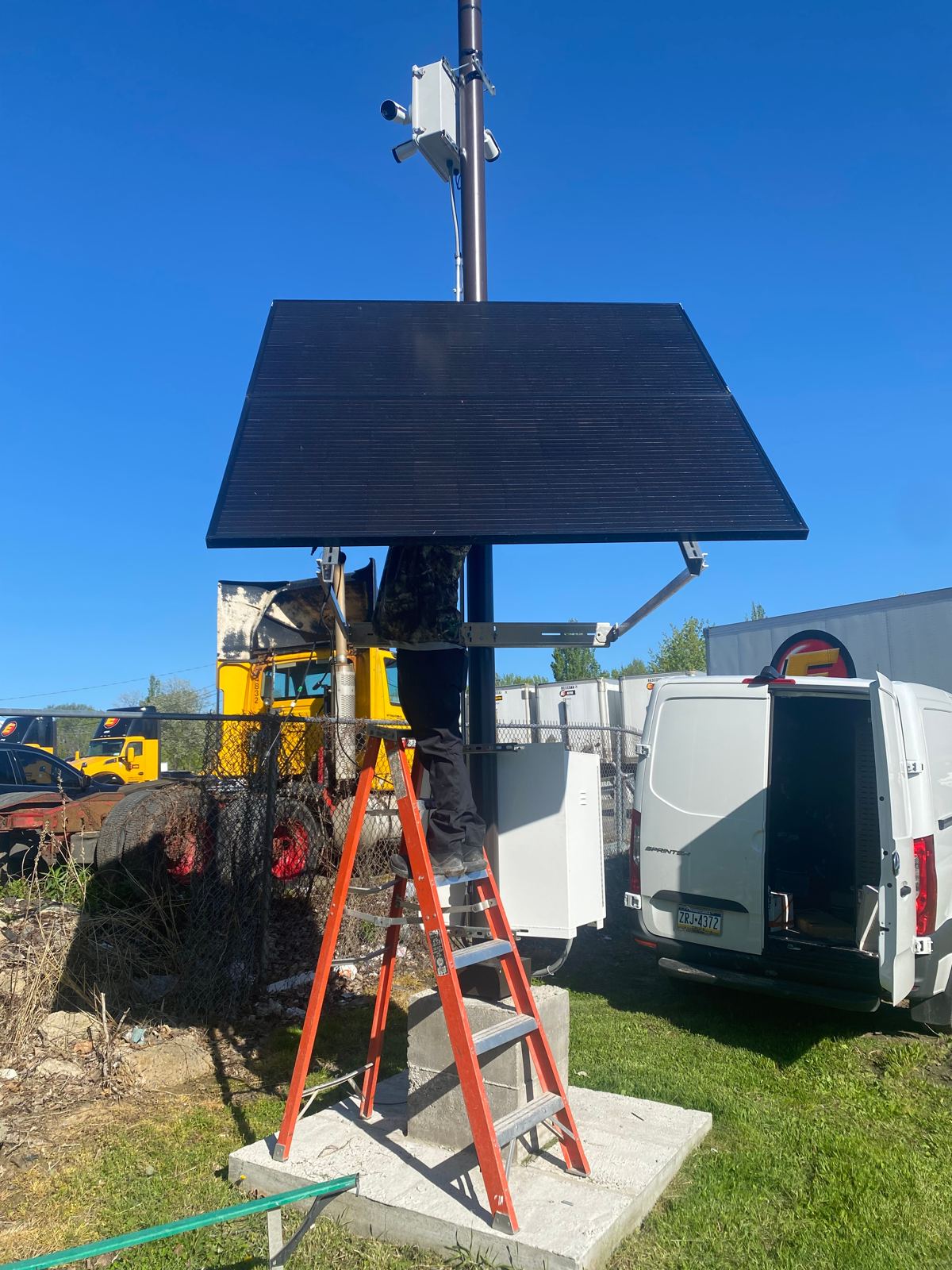 ACT Security Services technician installing a solar camera